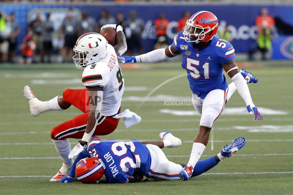 John Raoux Miami tight end Brevin Jordan, left, is brought down by Florida defensive back Jeawon Taylor (29) and linebacker Ventrell Miller (51) after a short gain during the first half of an NCAA college football game Saturday, Aug. 24, 2019, in Orlando, Fla. (AP Photo/John Raoux)