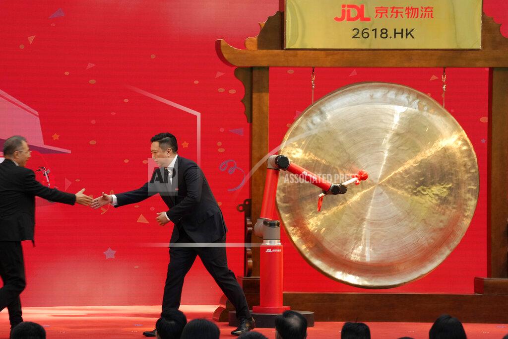 Ng Han Guan JD Logistics CEO Rui Yu shakes hands with a guest at a ceremony to virtually observe the listing of the subsidiary on the Hong Kong stock exchange from JD.com headquarters in Beijing on Friday, May 28, 2021. JD Logistics' shares jumped 14% in their trading debut Friday in Hong Kong. The company is a subsidiary of Chinese e-commerce giant JD.com. It is the latest technology company to list in the semi-autonomous Chinese city as Beijing intensifies scrutiny of the technology sector. (AP Photo/Ng Han Guan)