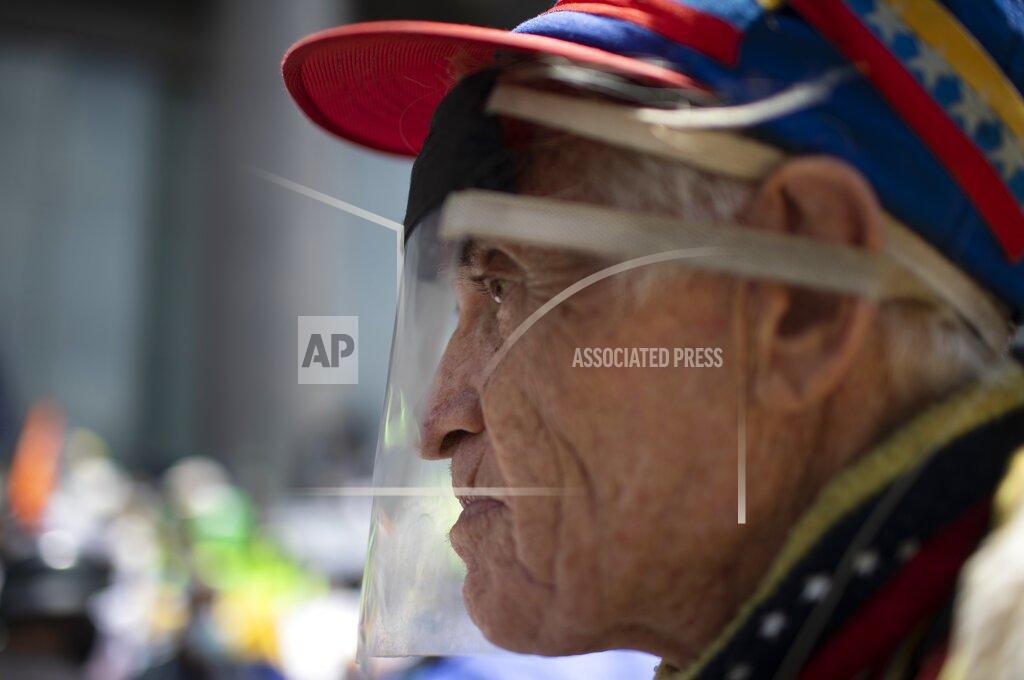 Ariana Cubillos Alberto Pena, 73, attends a protest demanding a more equitable and faster distribution of COVID-19 vaccines, in the Los Palos Grandes neighborhood of Caracas, Venezuela, Saturday, April 17, 2021. Pena said he is yet to be vaccinated. (AP Photo/Ariana Cubillos)