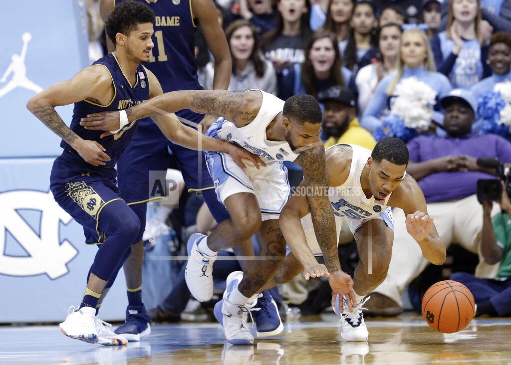 Gerry Broome Notre Dame's Prentiss Hubb, left, reaches for a loose ball with North Carolina's Seventh Woods and Garrison Brooks, right, during the first half of an NCAA college basketball game in Chapel Hill, N.C., Tuesday, Jan. 15, 2019. (AP Photo/Gerry Broome)
