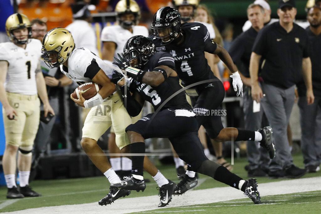 Marco Garcia Army quarterback Christian Anderson (13) gets shoved out of bounds by Hawaii defensive back Khoury Bethley (5) during the second half of an NCAA college football game Saturday, Nov. 30, 2019 in Honolulu. (AP Photo/Marco Garcia)
