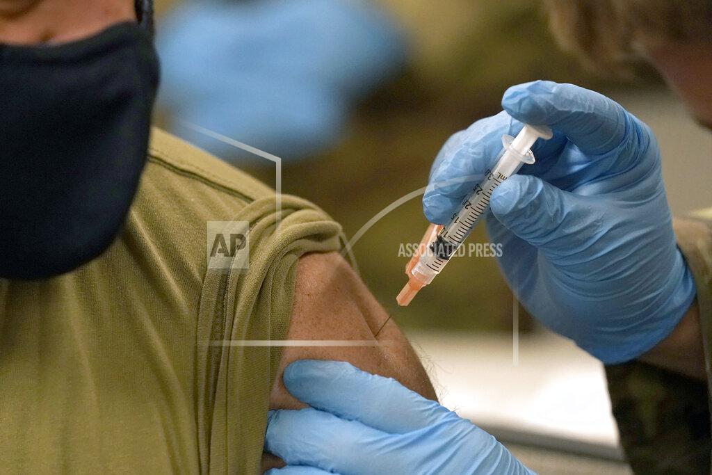 Rogelio V. Solis A member of the Mississippi National Guard receives a dose of the Moderna COVID-19 vaccine in his arm, by a fellow guard member, Wednesday, Dec. 23, 2020, in Flowood, Miss. One hundred doses of the vaccine were administered to both Mississippi Air and Army National Guard service members who serve as first responders and currently assist with the administering of the COVID-19 test at Mississippi Department of Health drive through community testing sites across the state. (AP Photo/Rogelio V. Solis)