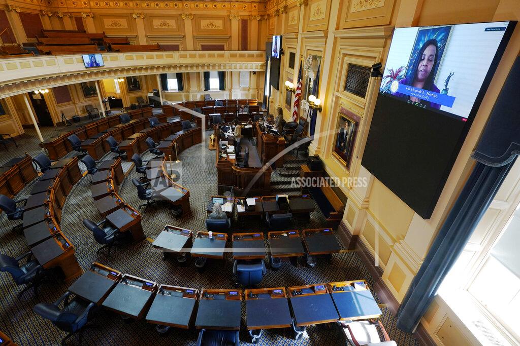 Steve Helber House speaker Del. Eileen Filler-Corn, D-Fairfax, at rostrum, listen as House majority leader, Del. Charniele Herring, D-Alexandria, on monitor, speaks in an empty Virginia House of Delegates chamber during a Zoom Legislative session at the Capitol in Richmond, Va., Wednesday, Feb. 10, 2021. (AP Photo/Steve Helber)