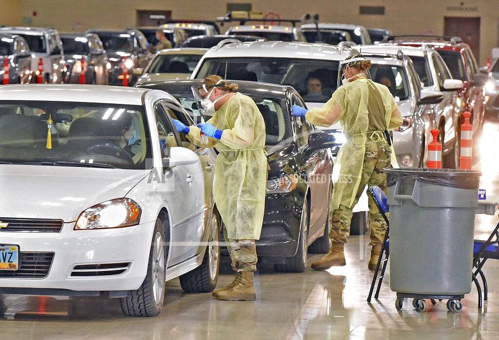Tom Stromme North Dakota National Guard soldiers Spc. Samantha Crabbe, left, and Master Sgt. Melanie Vincent administer COVID-19 tests, Tuesday, Nov. 17, 2020, inside the Bismarck Events Center in Bismarck, N.D. (Tom Stromme/The Bismarck Tribune via AP)