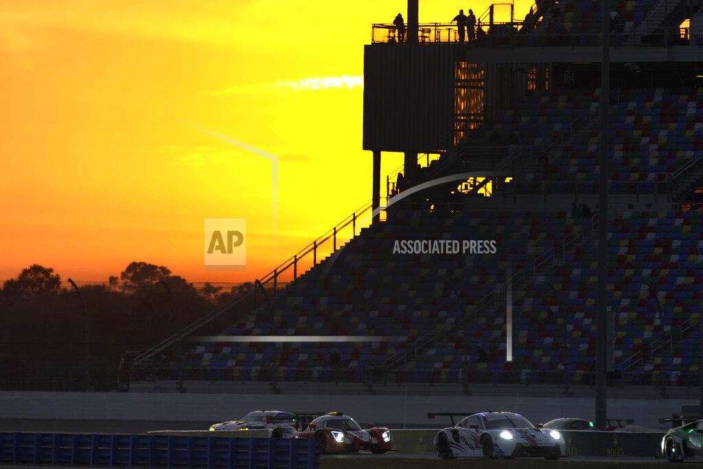 John Raoux Cars navigate the infield road course as the sun sets during the Rolex 24 hour auto race at Daytona International Speedway, Saturday, Jan. 30, 2021, in Daytona Beach, Fla. (AP Photo/John Raoux)