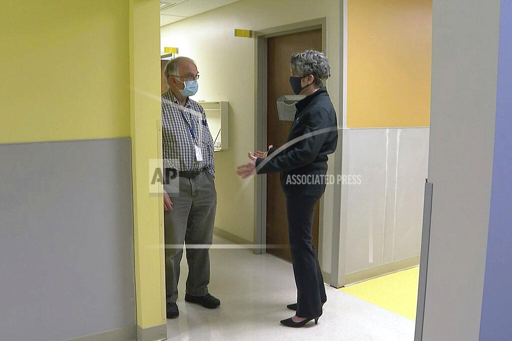 Linda Vail, health officer for Ingham County in Michigan, speaks with a colleague at their offices in Lansing, Mich., on Wednesday, Dec. 2, 2020. Vail has received emails and letters at her home saying she would be "taken down like the governor," which Vail took to be a reference to the thwarted attempt to kidnap Democratic Gov. Gretchen Whitmer. Even as other health officials are leaving, Vail is choosing to stay despite the threats. (AP Photo/Mike Householder)