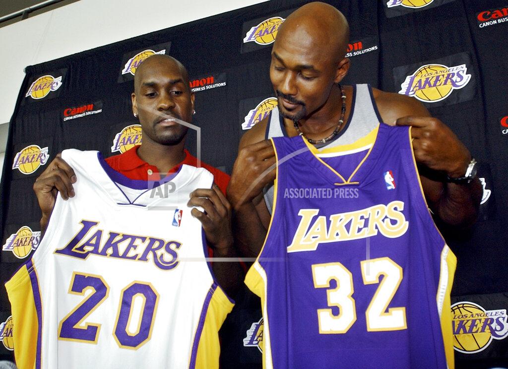 Ric Francis FILE - In this July 17, 2003 file photo Gary Payton, left, and Karl Malone display their new Los Angeles Lakers' jerseys during a news conference at the Staples Center in Los Angeles. The two players signed with the Lakers as free agents. Tom Brady’s departure from the New England Patriots on Tuesday, March 17, 2020, brings an end to one of the NFL’s most memorable eras. That’s happened plenty of times before in sports — a legendary star switching teams toward the end of his career. Malone was hoping for a triumphant ending when he signed with the Lakers in 2003 after 18 stellar seasons in Utah. But he came up just short in his quest for a title when the Lakers lost to Detroit in the 2004 NBA Finals. (AP Photo/Ric Francis, file)