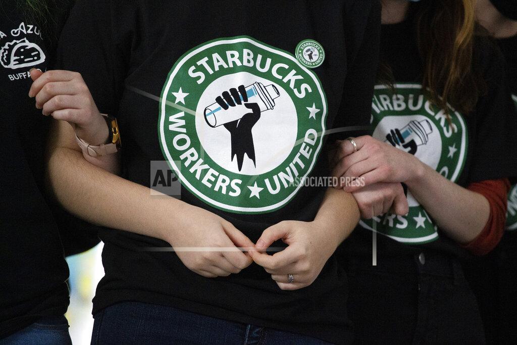 Joshua Bessex FILE - Starbucks employees and supporters react as votes are read during a union-election watch party on Thursday, Dec. 9, 2021, in Buffalo, N.Y. It’s become a common sight: jubilant Starbucks workers celebrating after successful votes to unionize at dozens of U.S. stores. But when the celebrations die down, a daunting hurdle remains. To win the changes they seek, like better pay and more reliable schedules, unionized stores must sit down with Starbucks and negotiate a contract. It’s a painstaking process that can take years. (AP Photo/Joshua Bessex, File)