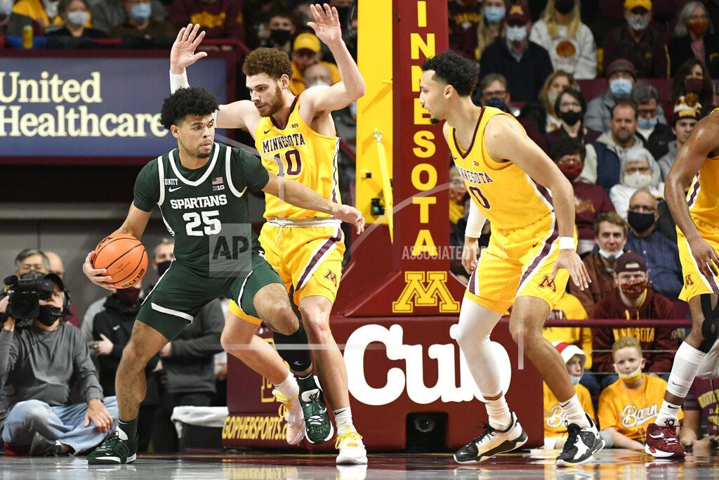 Craig Lassig Michigan State guard Malik Hall (25) tries to drive past Minnesota forward Jamison Battle (10) as guard Payton Willis watches during the first half an NCAA college basketball game Wednesday, Dec. 8, 2021, in Minneapolis. (AP Photo/Craig Lassig)