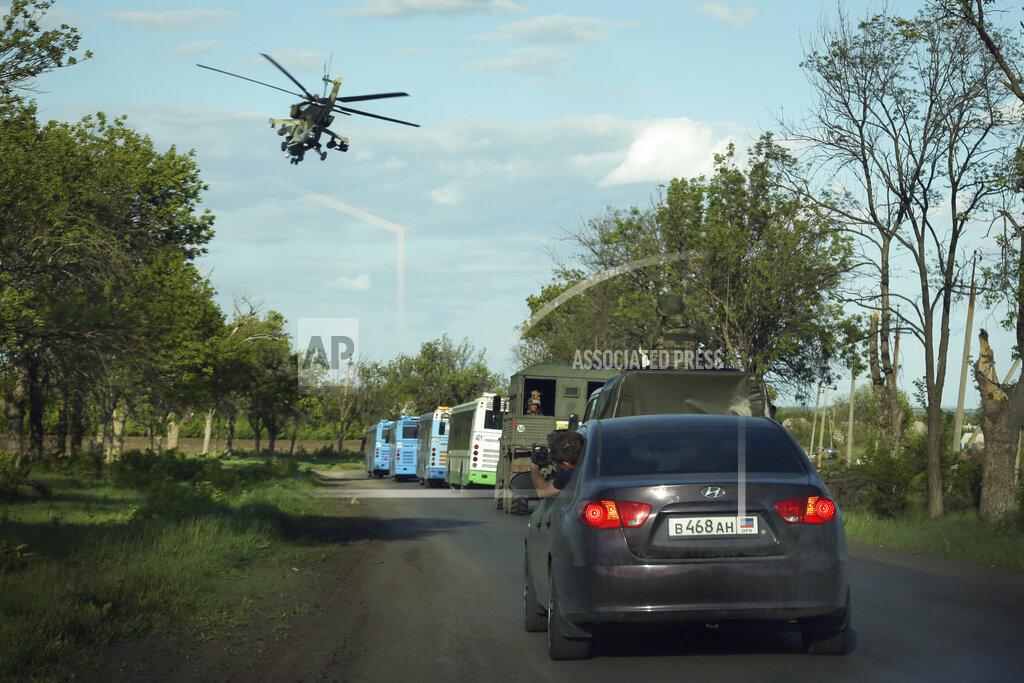 Alexei Alexandrov A Russian military helicopter flies over buses with Ukrainian servicemen evacuated from the besieged Mariupol's Azovstal steel plant traveling to a prison in Olyonivka, territory under the government of the Donetsk People's Republic, eastern Ukraine, Tuesday, May 17, 2022. More than 260 fighters, some severely wounded, were pulled from a steel plant on Monday that is the last redoubt of Ukrainian fighters in the city and transported to two towns controlled by separatists, officials on both sides said. (AP Photo/Alexei Alexandrov)