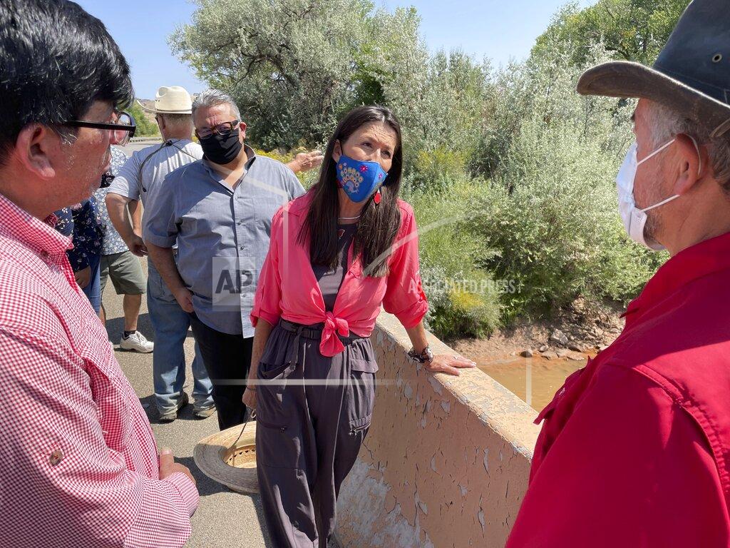 Susan Montoya Bryan This Aug. 31, 2021 photo shows U.S. Rep. Teresa Leger Fernández, center, talking with acequia officials at a crossing over the Rio Chama during a tour near Abiquiu, New Mexico. The traditional irrigation systems known as acequias are facing pressure amid persistent drought and warming temperatures. (AP Photo/Susan Montoya Bryan)