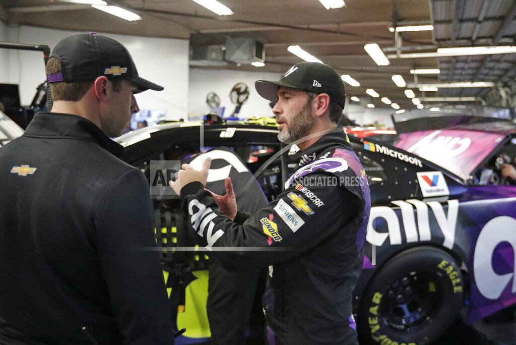 Jimmie Johnson, right, talks with a crew member in his garage after a practice session for the NASCAR Daytona 500 auto race at Daytona International Speedway, Friday, Feb. 14, 2020, in Daytona Beach, Fla. (AP Photo/John Raoux)