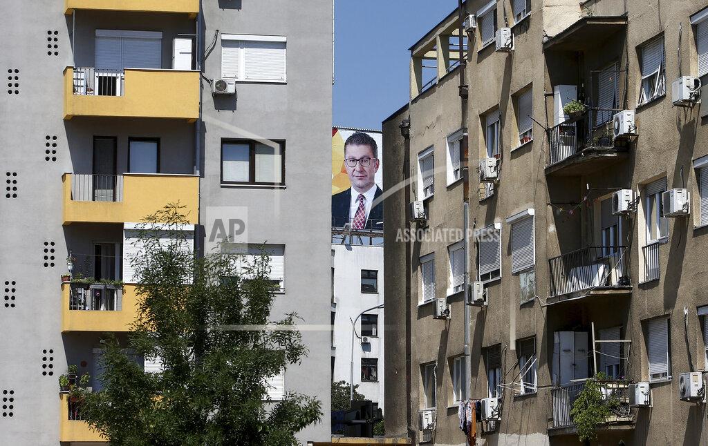 Boris Grdanoski A portrait of the leader of the largest opposition party VMRO-DPMNE Hristijan Mickoski, is displayed as part of an electoral campaign poster, between two buildings in Skopje, North Macedonia on Saturday, July 11, 2020. North Macedonia holds its first parliamentary election under its new country name this week, with voters heading to the polls during an alarming spike of coronavirus cases in the small Balkan nation. (AP Photo/Boris Grdanoski)