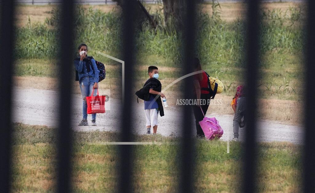 Eric Gay Migrants pass a fence near the International bridge where thousands of Haitian migrants have created a makeshift camp, Saturday, Sept. 18, 2021, in Del Rio, Texas. (AP Photo/Eric Gay)
