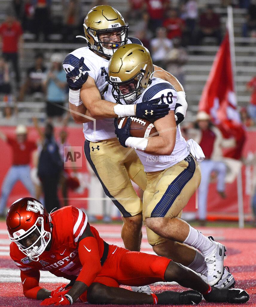 Eric Christian Smith Navy safety Kevin Brennan (10) celebrates his interception in the end zone intended for Houston wide receiver Marquez Stevenson, bottom, with Evan Fochtman during the second half of an NCAA college football game, Saturday, Nov. 30, 2019, in Houston. (AP Photo/Eric Christian Smith)