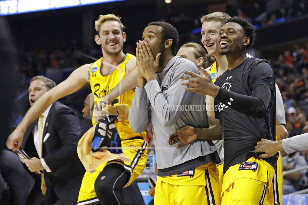 Gerry Broome FILE - In this March 16, 2018, file photo, UMBC players celebrate a teammate's basket during the second half against Virginia at the NCAA men's college basketball tournament in Charlotte, N.C. UMBC defeated Virginia 74-54. (AP Photo/Gerry Broome, File)