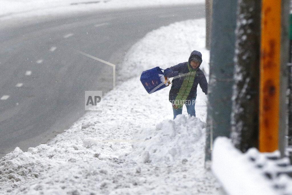 A pedestrian walks through deep snow after an overnight snowfall, Monday, Dec. 2, 2019, in Marlborough, Mass. (AP Photo/Bill Sikes)
