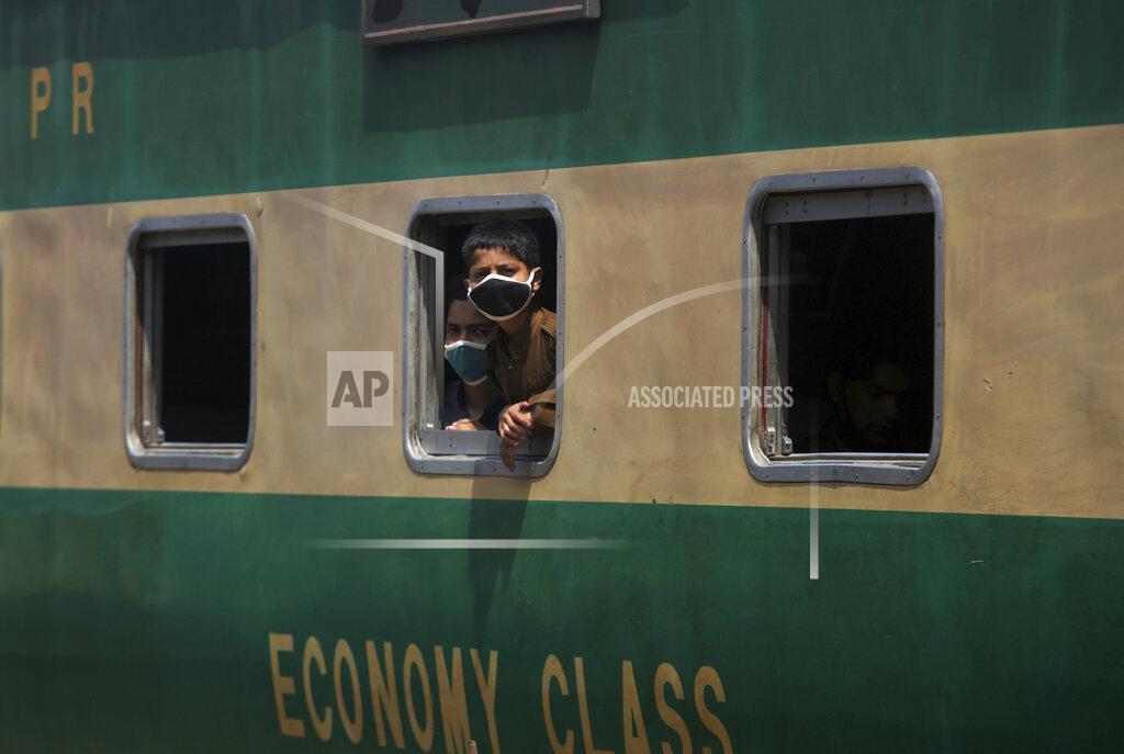 Fareed Khan Boys wearing protective masks to help curb the spread of the coronavirus, look out the window of a train at a railway station, in Karachi, Pakistan, Saturday, Jan. 6, 2020. (AP Photo/Fareed Khan)