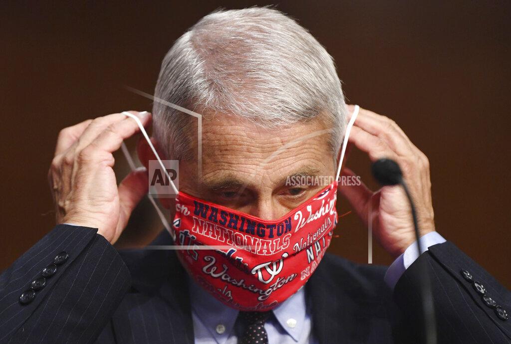 Kevin Dietsch Dr. Anthony Fauci, director of the National Institute for Allergy and Infectious Diseases, lowers his face mask as he prepares to testify before a Senate Health, Education, Labor and Pensions Committee hearing on Capitol Hill in Washington, Tuesday, June 30, 2020. (Kevin Dietsch/Pool via AP)