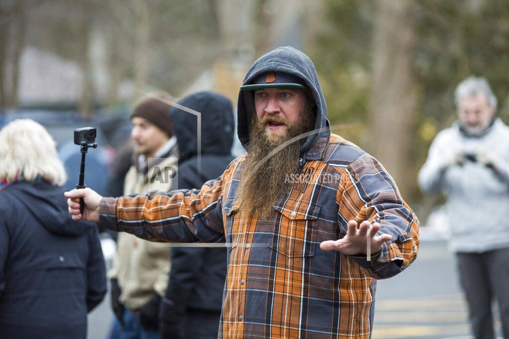 Matt Parker Skylar Bennett joins protesters at Newfields Town Hall on Sunday, Jan. 3, 2021, in Newfields, N.H., to oppose the mask mandate and other coronavirus restrictions supported by state and federal public health officials. (Matt Parker/Portsmouth Herald via AP)