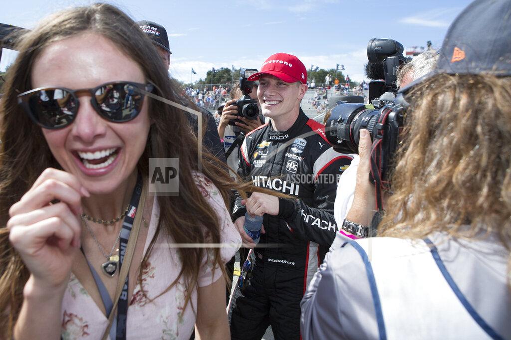 David Royal Josef Newgarden, center, and his fiancee Ashley Welch, left, celebrate in his pit after he won the championship after an IndyCar auto race at Laguna Seca Raceway in Monterey, Calif., Sunday, Sept. 22, 2019. (AP Photo/David Royal)
