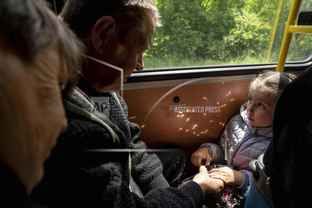 Evgeniy Maloletka A girl with her grandparents from Lyman ride in the bus during evacuation near Lyman, Ukraine, Wednesday, May 11, 2022. (AP Photo/Evgeniy Maloletka)