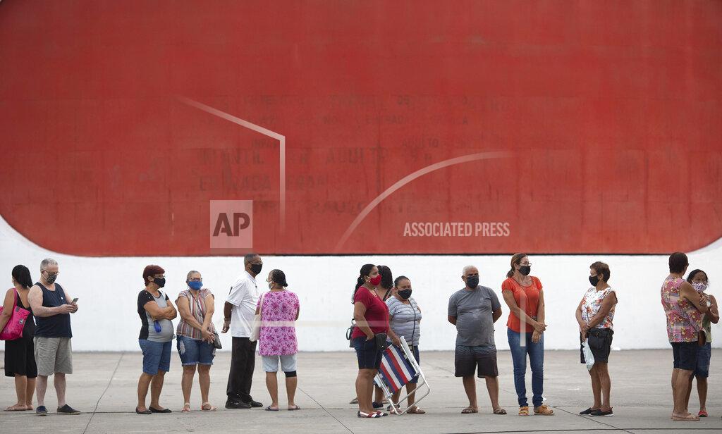 Silvia Izquierdo People wait in line to get the Sinovac vaccine at a COVID-19 vaccination point for seniors in Duque de Caxias, Brazil, Wednesday, March 24, 2021. (AP Photo/Silvia Izquierdo)