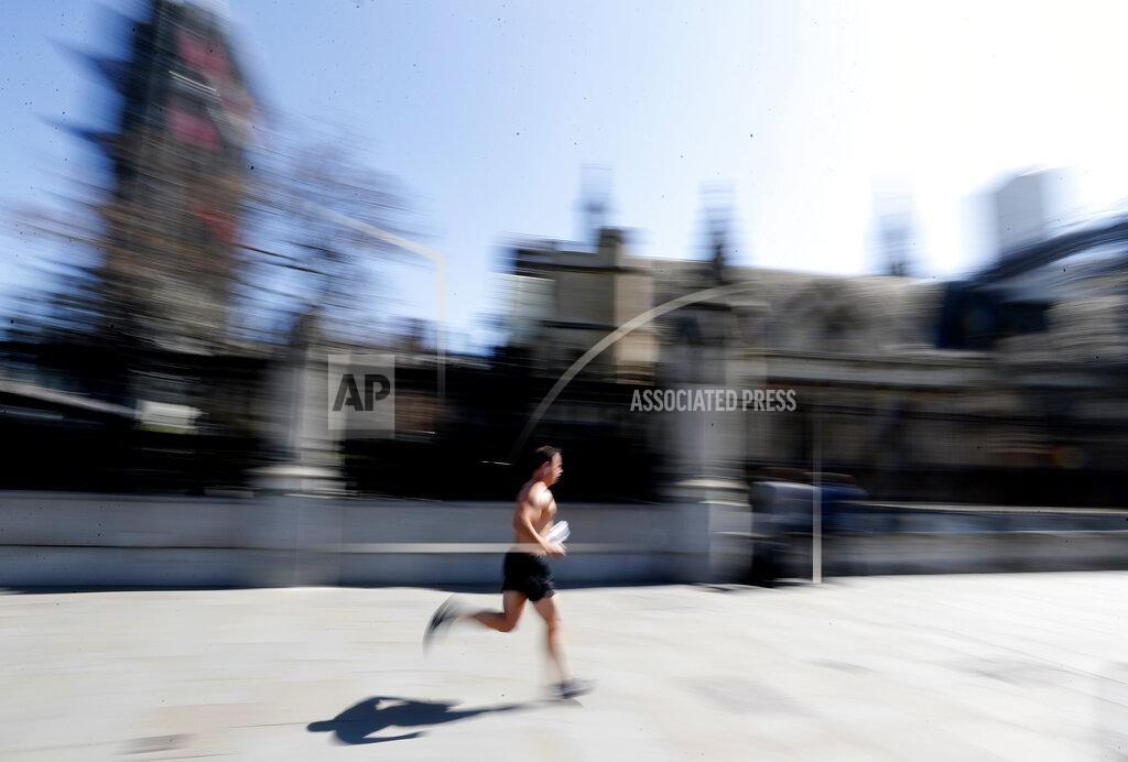 Frank Augstein A jogger runs alongside Parliament in central London, Wednesday April 22, 2020 during the coronavirus lockdown. (AP Photo/Frank Augstein)