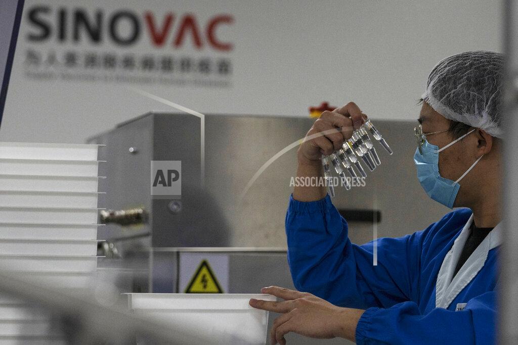 A worker inspects syringes of a vaccine for COVID-19 produced by Sinovac at its factory in Beijing on Thursday, Sept. 24, 2020. With rich countries snapping up supplies of COVID-19 vaccines, some parts of the world may have to rely on Chinese-developed shots to conquer the outbreak. The question: Will they work? (AP Photo/Ng Han Guan)