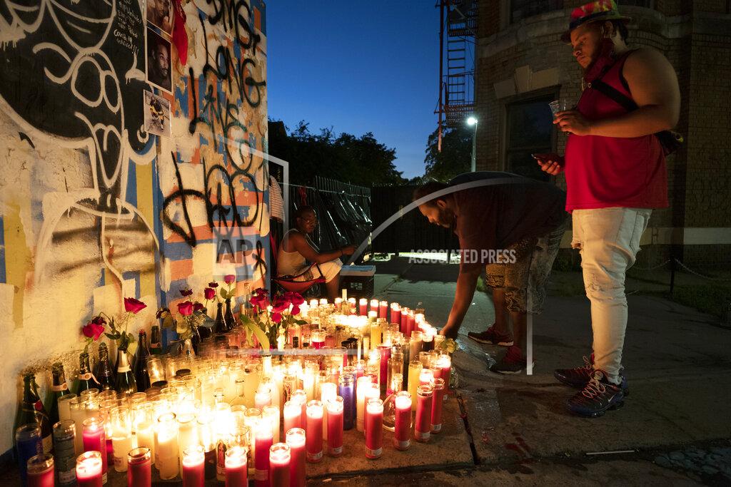 Mark Lennihan FILE - Friends of Wesley Green light candles at a sidewalk memorial for him, July 28, 2020 in the Ditmas Park neighborhood of New York. Green, 32, was shot and killed near his home the day before. Police recorded 280 killings through Aug. 23. By comparison there were nearly 2,300 murders in New York City in 1990 and in 2000 the number was 673. (AP Photo/Mark Lennihan)