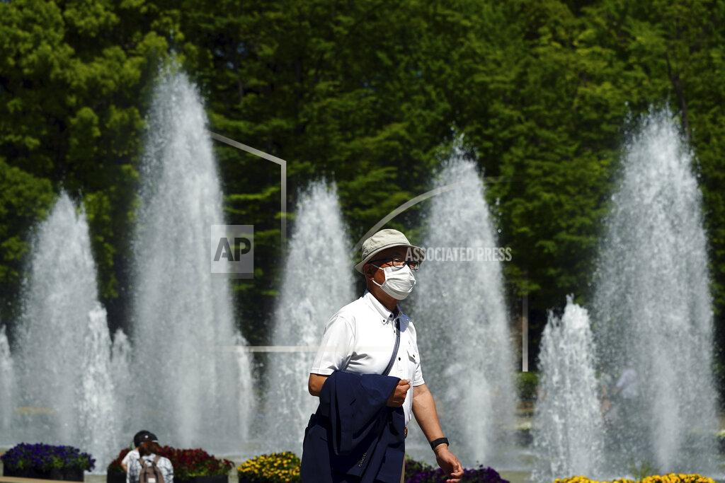 Eugene Hoshiko A man wearing a protective mask to help curb the spread of the coronavirus walks through a park Wednesday, April 21, 2021, in Tokyo. The Japanese capital confirmed more than 840 new coronavirus cases on Wednesday. (AP Photo/Eugene Hoshiko)