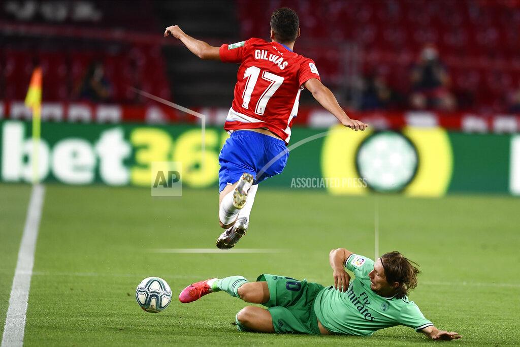 Jose Breton Granada's Gil Dias, left, is tackled by Real Madrid's Luka Modric during the Spanish La Liga soccer match between Granada and Real Madrid at the Los Carmenes stadium in Granada, Spain, Monday, July 13, 2020. (AP Photo/Jose Breton)