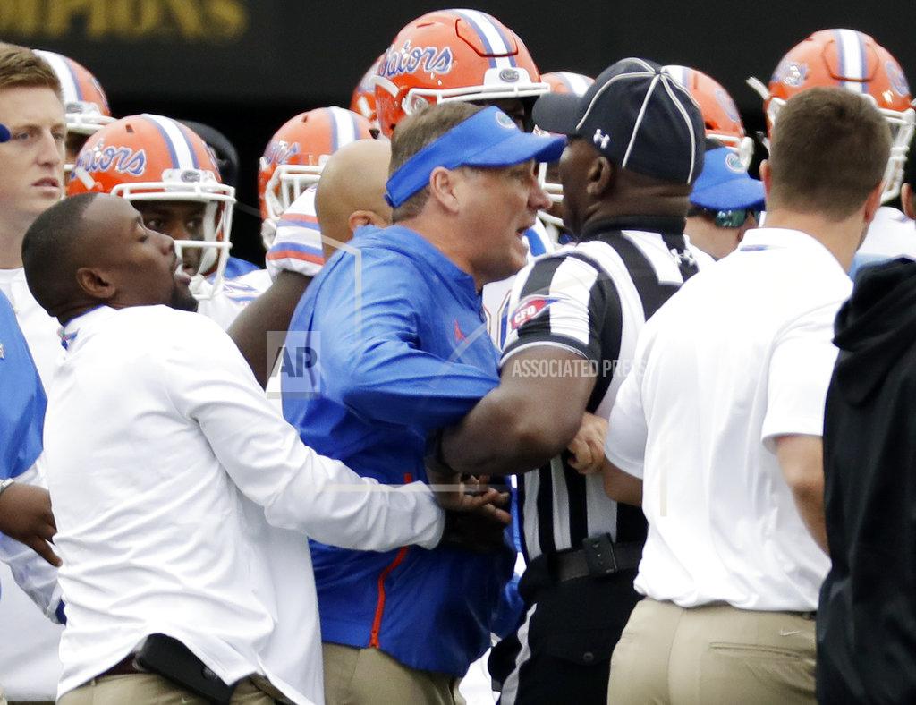 Mark Humphrey Florida head coach Dan Mullen, center, is restrained during a verbal confrontation with Vanderbilt coaches and players in the first half of an NCAA college football game Saturday, Oct. 13, 2018, in Nashville, Tenn. (AP Photo/Mark Humphrey)