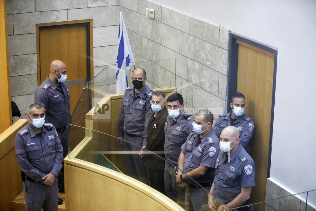Sebastian Scheiner Yakub Kadari is surrounded by guards as they stand in a courtroom in Nazareth, Israel, after he and three other Palestinian fugitives were captured on Saturday, Sept. 11, 2021. Israeli police on Saturday said they have arrested four of the six Palestinians who broke out of a maximum-security prison this week — including a famed militant leader whose exploits over the years have made him a well-known figure in Israel. (AP Photo/Sebastian Scheiner)