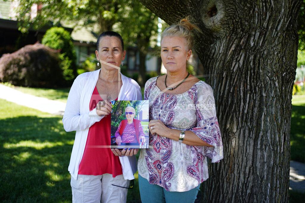 Matt Slocum Angela Ermold, right, and her sister, Denise Gracely, pose with a photo of their mother, Marian Rauenzahn, Thursday, June 17, 2021, in Fleetwood, Pa. Pandemic restrictions are falling away almost everywhere — except inside many of America’s nursing homes. “They have protected them to death,” said Gracely. (AP Photo/Matt Slocum)