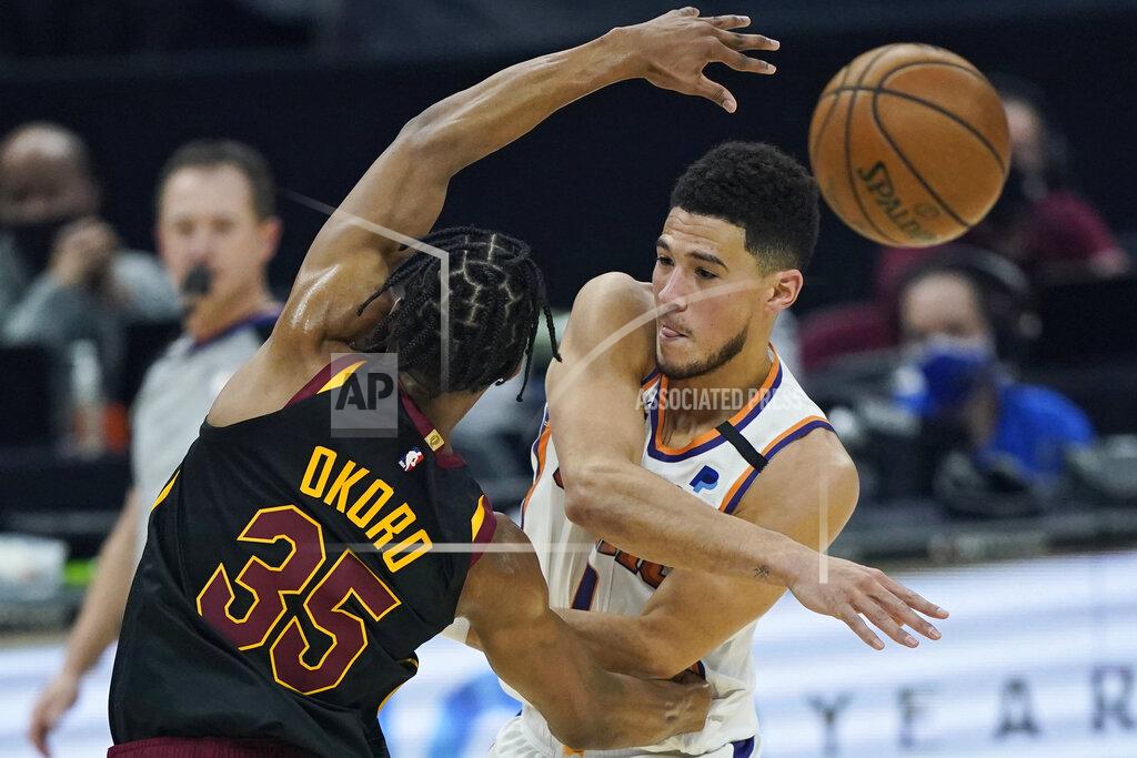 Tony Dejak Phoenix Suns' Devin Booker, right, passes against Cleveland Cavaliers' Isaac Okoro in the first half of an NBA basketball game, Tuesday, May 4, 2021, in Cleveland. (AP Photo/Tony Dejak)