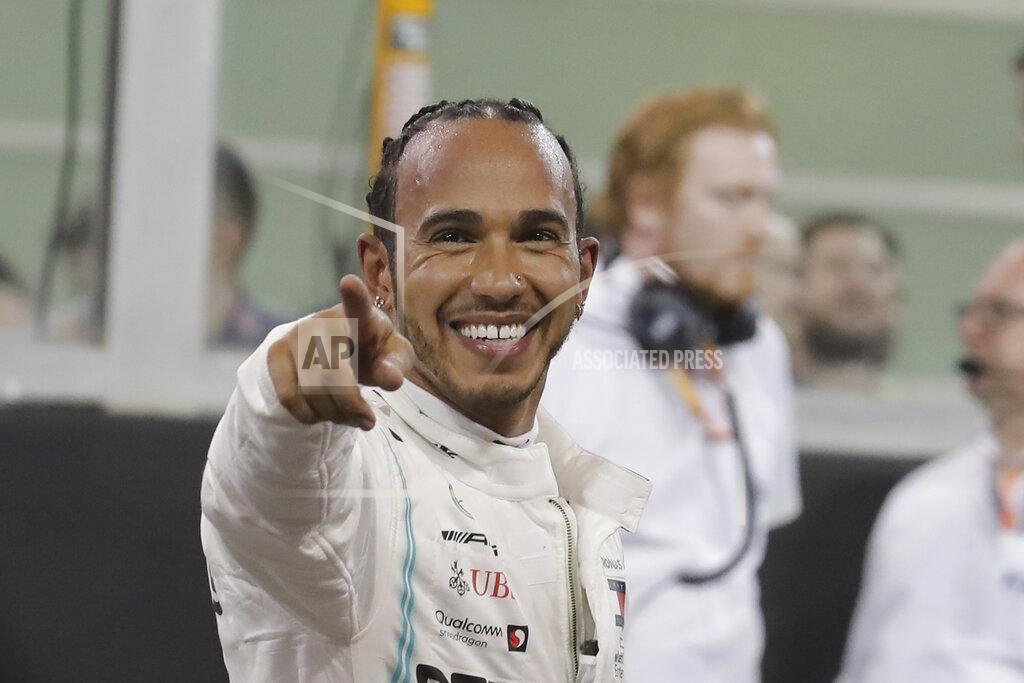 Hassan Ammar Mercedes driver Lewis Hamilton of Britain celebrates pole position during the qualifying session at the Yas Marina racetrack in Abu Dhabi, United Arab Emirates, Saturday, Nov. 30, 2019. The Emirates Formula One Grand Prix will take place on Sunday. (AP Photo/Hassan Ammar)