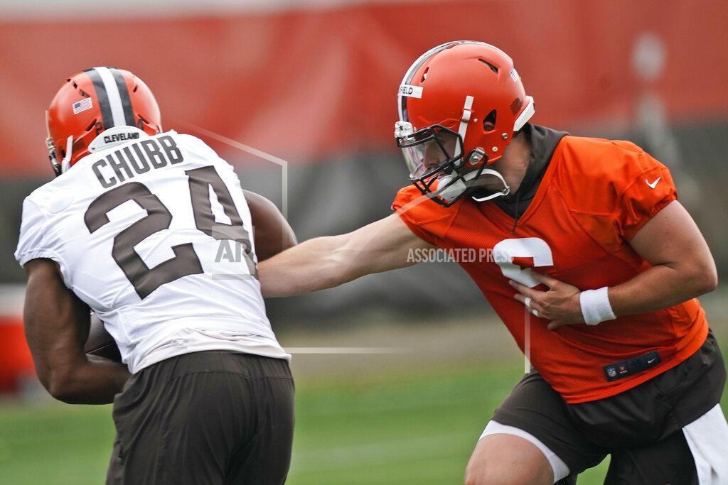 Cleveland Browns quarterback Baker Mayfield, right, hands the ball off to running back Nick Chubb during an NFL football practice, Thursday, July 29, 2021, in Berea, Ohio. (AP Photo/Tony Dejak)