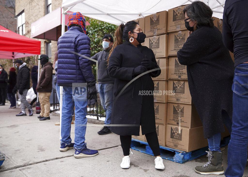 Volunteer Gloria Martinez, left, speaks with Sofia Moncayo, who runs a food distribution program through Mosaic West Queens Church in the Sunnyside neighborhood of the Queens borough of New York on Monday, Feb. 22, 2021. Martinez began volunteering for the program after losing one of her two jobs due to the coronavirus pandemic. (AP Photo/Emily Leshner)