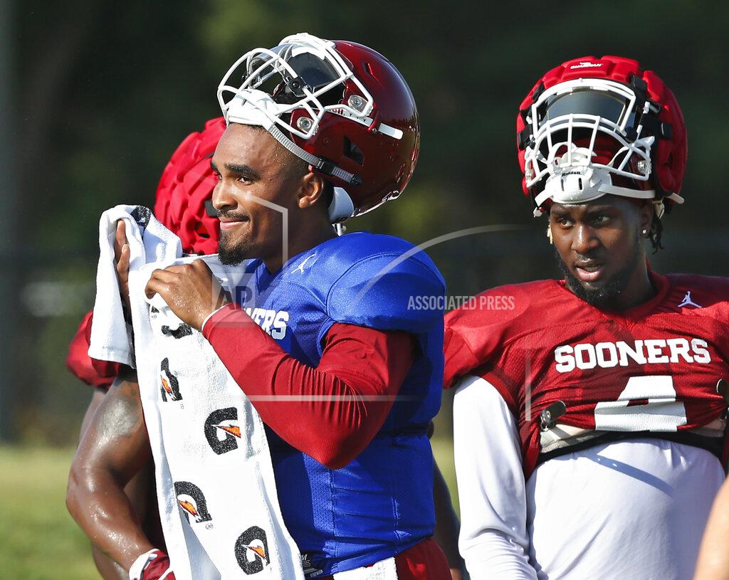 Sue Ogrocki Oklahoma quarterback Jalen Hurts, left, and running back Trey Sermon, right, take a breather during an NCAA college football practice in Norman, Okla., Monday, Aug. 5, 2019. (AP Photo/Sue Ogrocki)