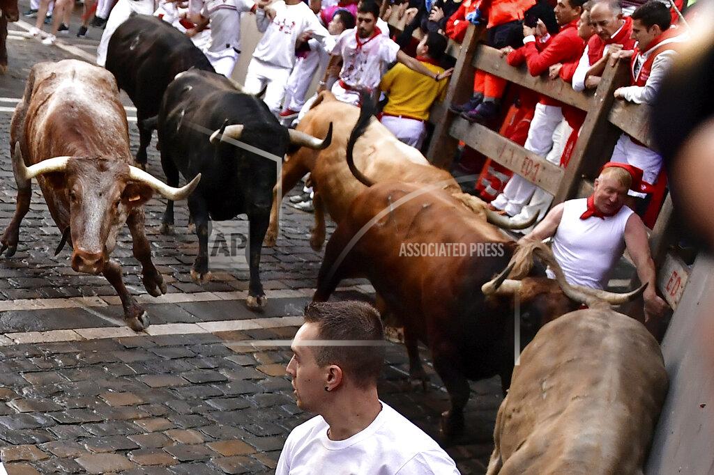 Alvaro Barrientos People run through the streets with fighting bulls and steers during the first day of the running of the bulls at the San Fermin Festival in Pamplona, northern Spain, Thursday, July 7, 2022. Revelers from around the world flock to Pamplona every year for nine days of uninterrupted partying in Pamplona's famed running of the bulls festival which was suspended for the past two years because of the coronavirus pandemic. (AP Photo/Alvaro Barrientos)