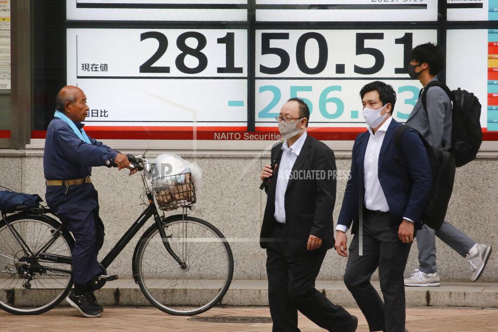 Koji Sasahara People walk by an electronic stock board of a securities firm in Tokyo, Wednesday, May 19, 2021. Asian shares fell Wednesday, tracking a decline on Wall Street led by big technology stocks. (AP Photo/Koji Sasahara)