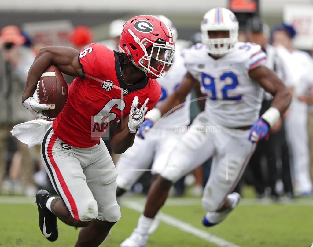 John Raoux Georgia running back James Cook (6) gains yardage as he is pressured by Florida defensive lineman Jabari Zuniga (92) during the first half of an NCAA college football game Saturday, Oct. 27, 2018, in Jacksonville, Fla. (AP Photo/John Raoux)