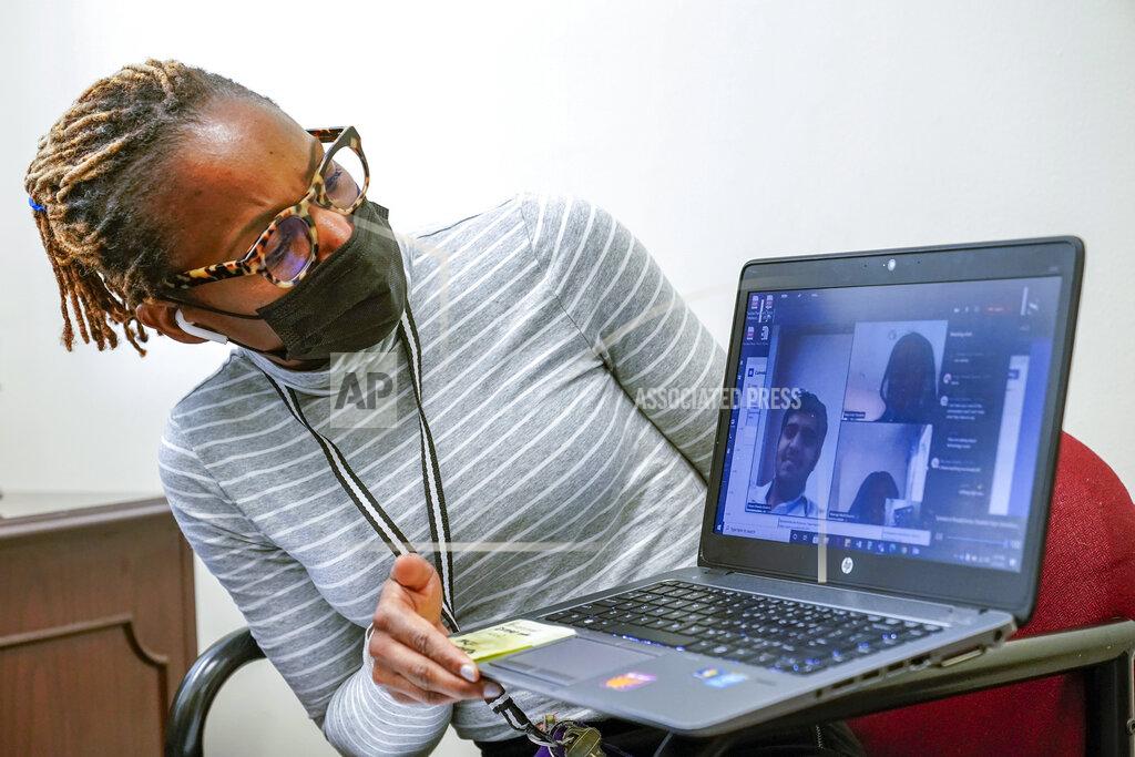 Mary Altaffer High School Councilor Nadia Pearce, right, speaks to a group of Juniors and Seniors via video conference, Thursday, Feb. 25, 2021, in Bridgeport. Conn. School counselors in many urban, high needs districts have been consumed with efforts to help students engage with their schoolwork since the pandemic hit. (AP Photo/Mary Altaffer)