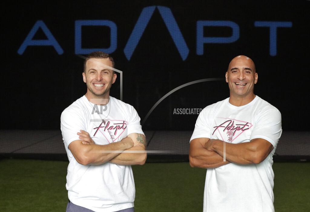 Wilfredo Lee In this Thursday, June 4, 2020 photo, ADAPT gym owners Scott Grondin, left, and Jorge Sanchez pose for a photo at the gym in North Miami, Fla. The business partners and co-founders of the gym just got the OK to reopen their Miami area studio Monday after three months. Desperate to keep their carefully built 15-person team, they gave up their own salaries to keep the entire staff at full pay, relying on them to quickly pivot to online fitness training. (AP Photo/Wilfredo Lee)