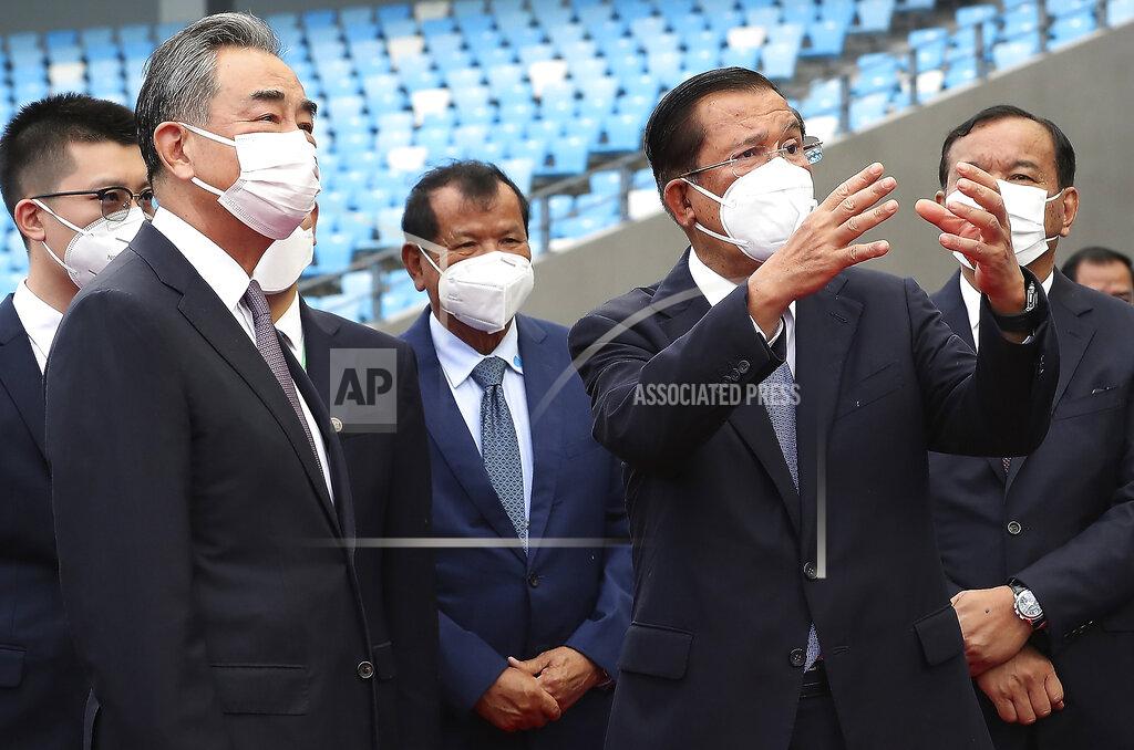Lon Jadina Chinese Foreign Minister Wang Yi, front left, listens to Cambodia's Prime Minister Hun Sen, front right, during a tour to the Morodok Techo National Stadium, as the stadium was handed over to the the Cambodian organizing committee of the Southeast Asian Games, in Phnom Penh, Cambodia, Sunday, Sept. 12, 2021. Wang is visiting Cambodia, where he met with Hun Sen and other officials to discuss COVID-19 and other regional issues. (Lon Jadina/Pool Photo via AP)