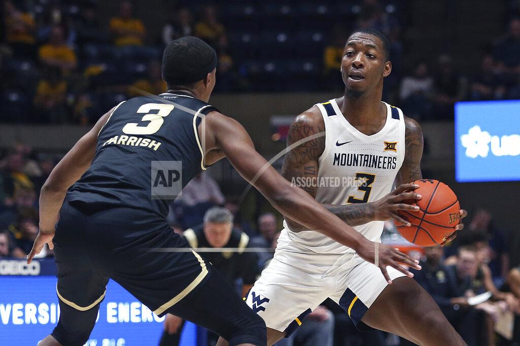 Kathleen Batten West Virginia forward Gabe Osabuohien (3) looks to move the ball past Oakland forward Micah Parrish (3) during the second half of an NCAA college basketball game in Morgantown, W.Va., Tuesday, Nov. 9, 2021. (AP Photo/Kathleen Batten)
