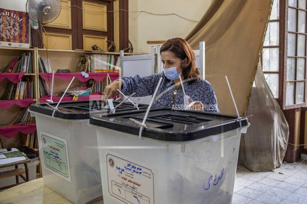 Nariman El-Mofty A woman casts her vote on the first day in the second and final stage of the country's parliamentary elections in Cairo, Egypt, Saturday, Nov. 7, 2020. Egyptians began voting on Saturday after a relatively low turnout in the first stage that embarrassed the government of President Abdel-Fattah el-Sissi. (AP Photo/Nariman El-Mofty)
