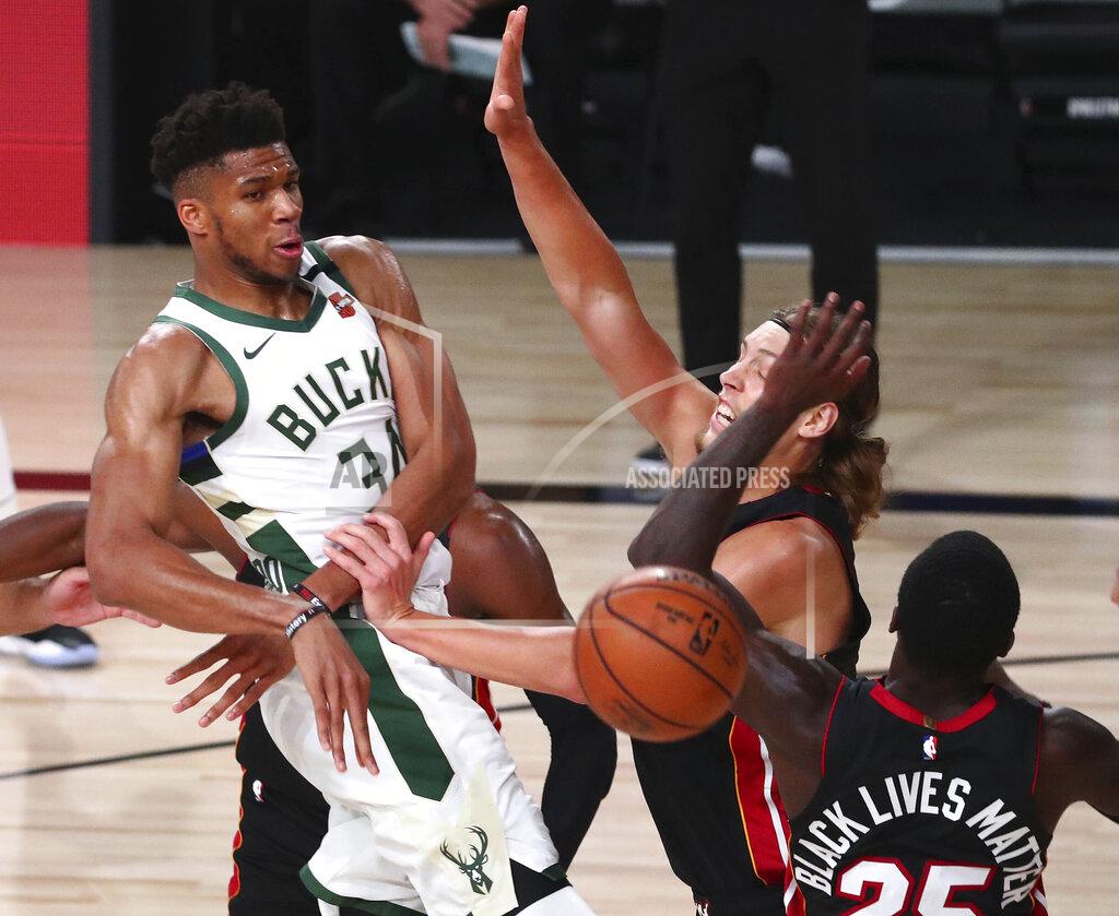 Kim Klement Milwaukee Bucks forward Giannis Antetokounmpo (34) passes the ball against Miami Heat forward Kelly Olynyk (9) and guard Kendrick Nunn (25) during the second half of an NBA basketball game Thursday, Aug. 6, 2020, in Lake Buena Vista, Fla. (Kim Klement/Pool Photo via AP)
