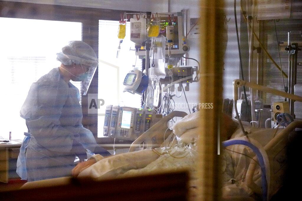 Elaine Thompson Registered nurse Andraya Zelle treats a patient in the COVID intensive care unit at UW Medical Center-Montlake, Tuesday, Jan. 26, 2021, in Seattle. King County, where the hospital is located, has been on a downward trend of COVID-19 cases after two-and-a-half straight months of increases. But the current lull could be, and some experts believe will be, upended as more contagious variants of the virus spread throughout United States. (AP Photo/Elaine Thompson)